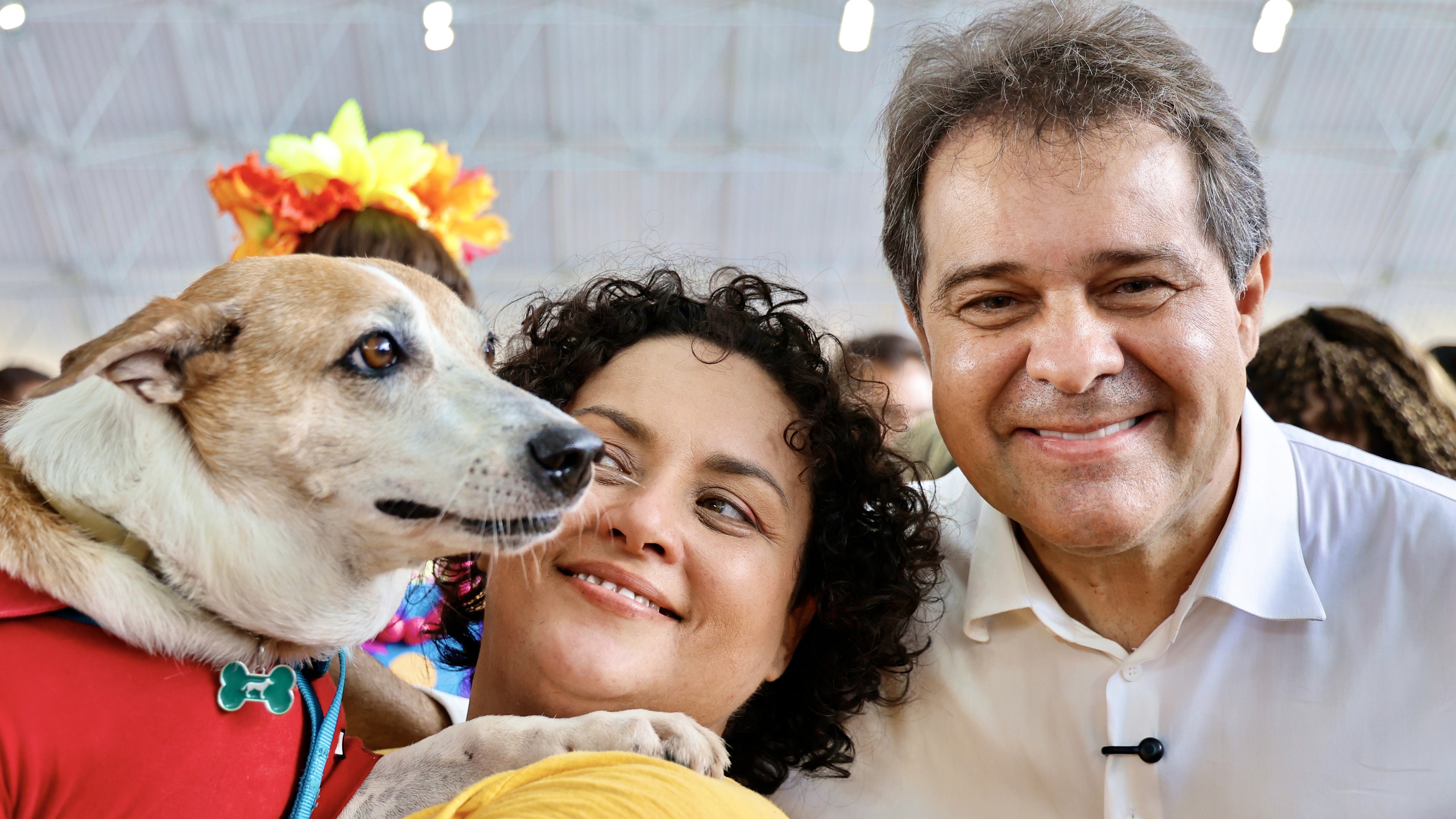Prefeito Evandro posa com uma mulher que está com um cachorro no colo